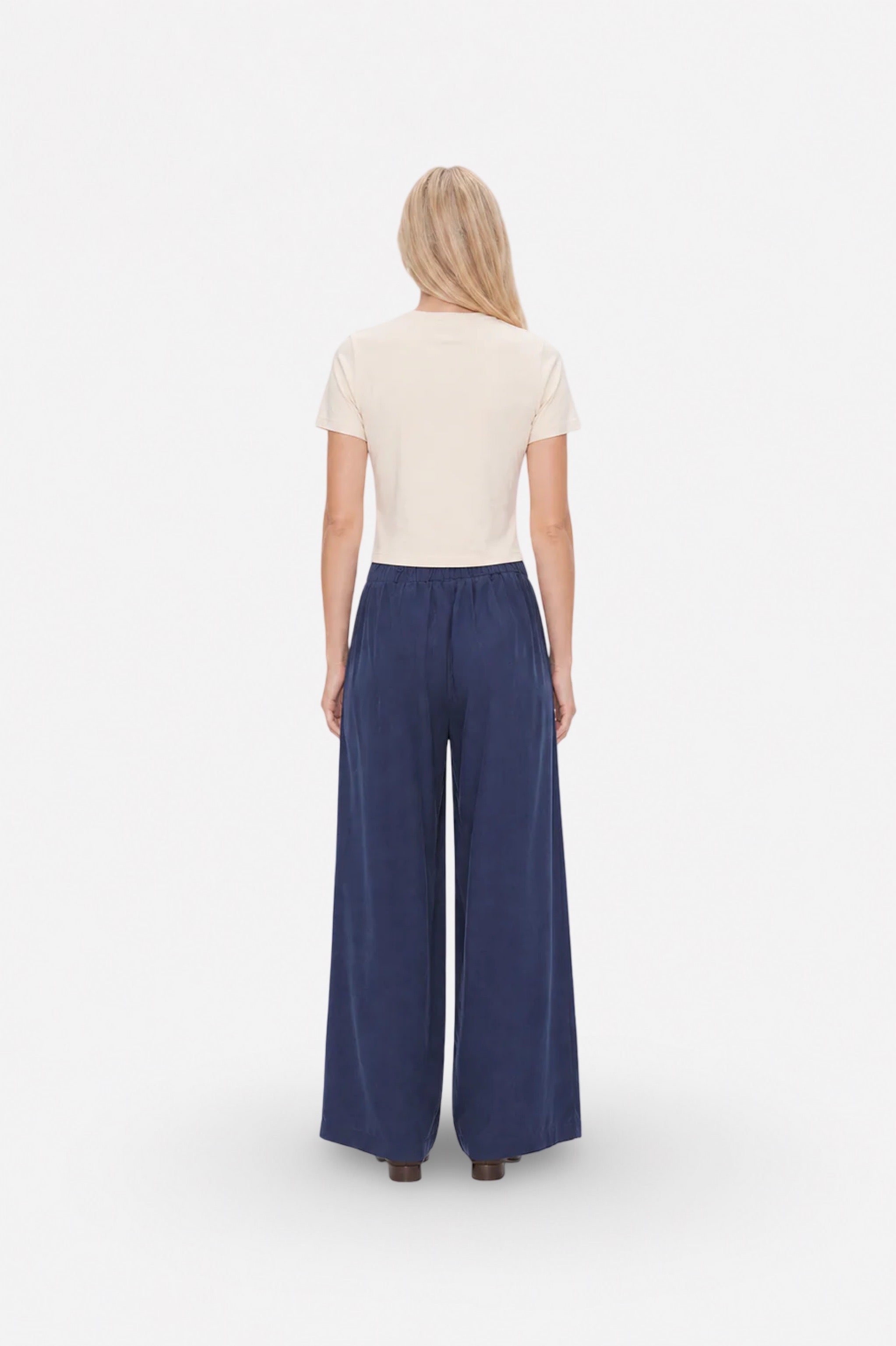 Navy Tencel fabric wide-leg pleated pants from Ginaci Türkiye with relaxed fit and stylish design, shown on a model.