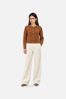 Brown knit cardigan with pearl button details from Ginaci Türkiye, styled in a casual, cozy look.
